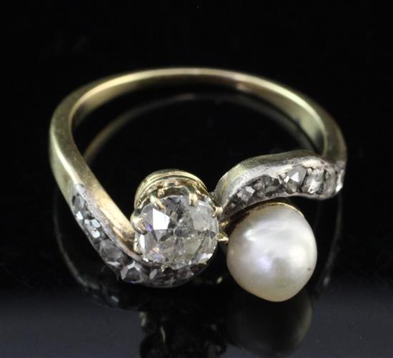 An early 20th century gold, diamond and cultured pearl cross over ring, size M.